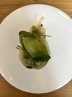 A beautifully styled plate of food with matte forest green accents in the setting.