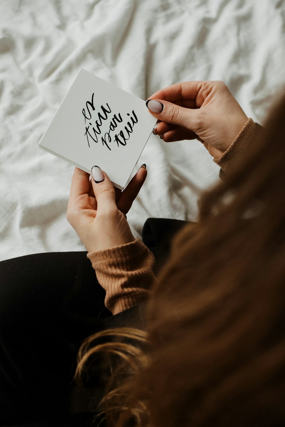 a woman holding a piece of paper with writing on it