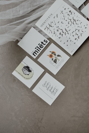 Close-up of delicate hand-lettered cards and prints displayed on a wooden table.