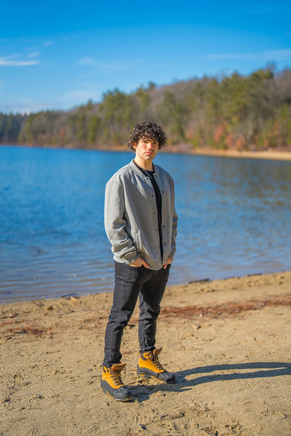 a man standing on a beach next to a body of water