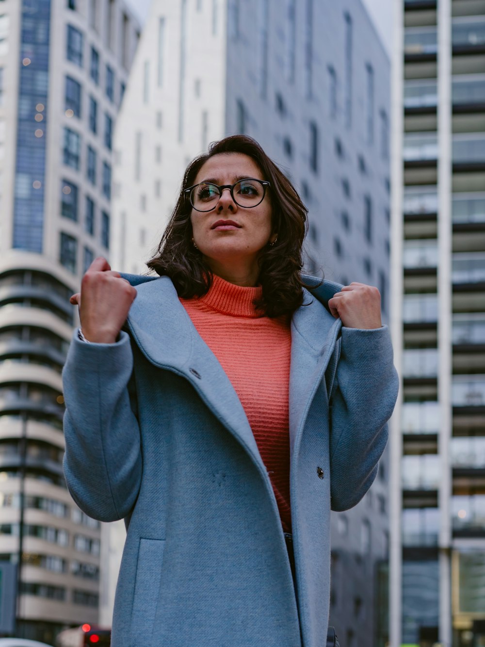 a woman in a blue coat is posing for a picture