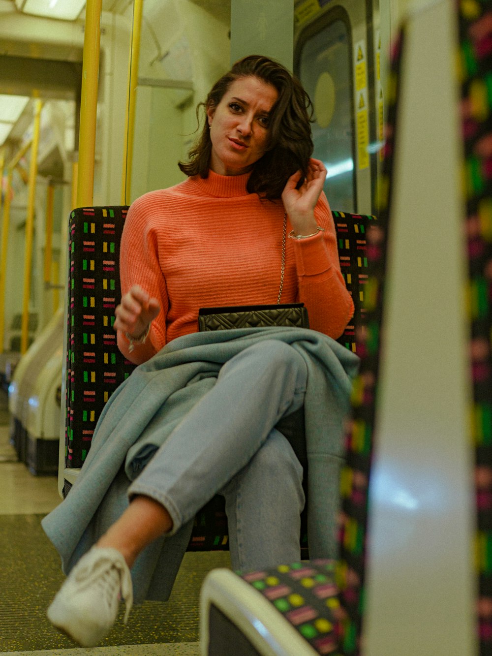 a woman sitting on a train with a laptop