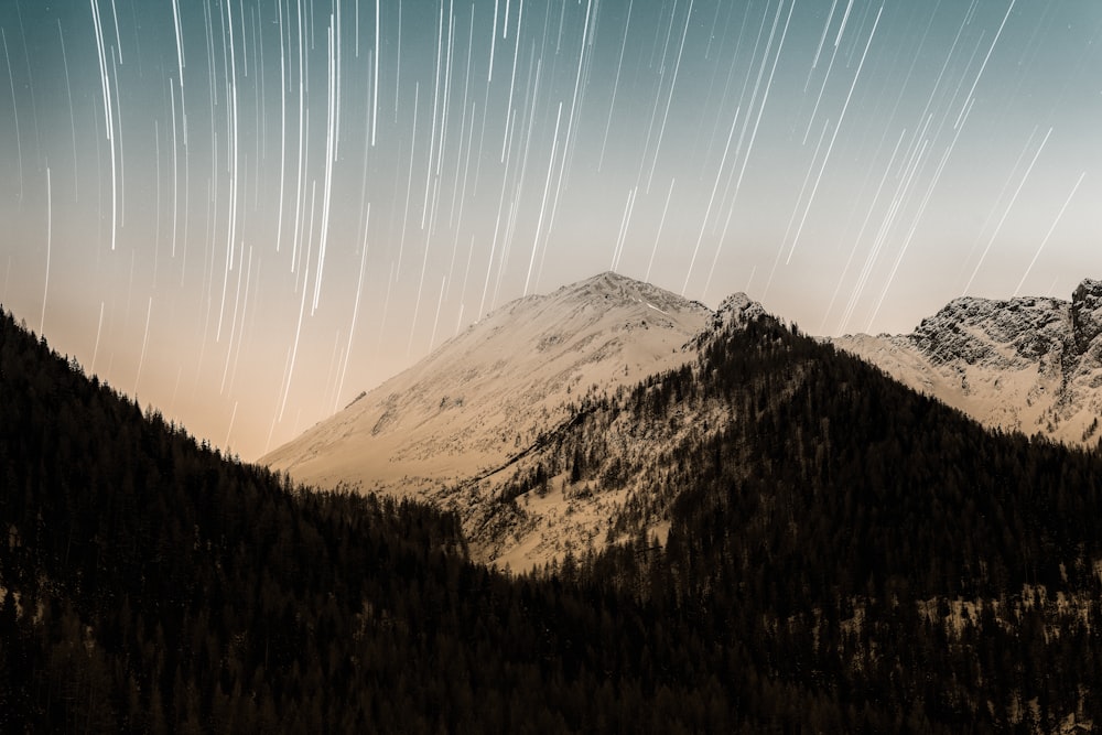 a mountain range with a star trail in the sky