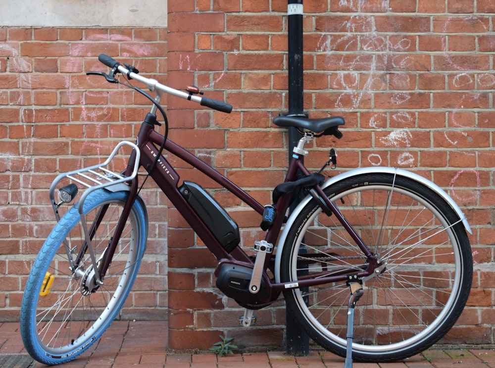 a bicycle parked next to a brick wall