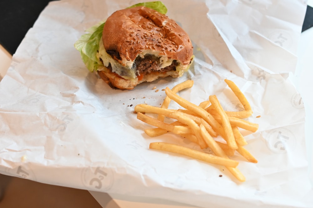a hamburger and french fries sitting on a piece of paper