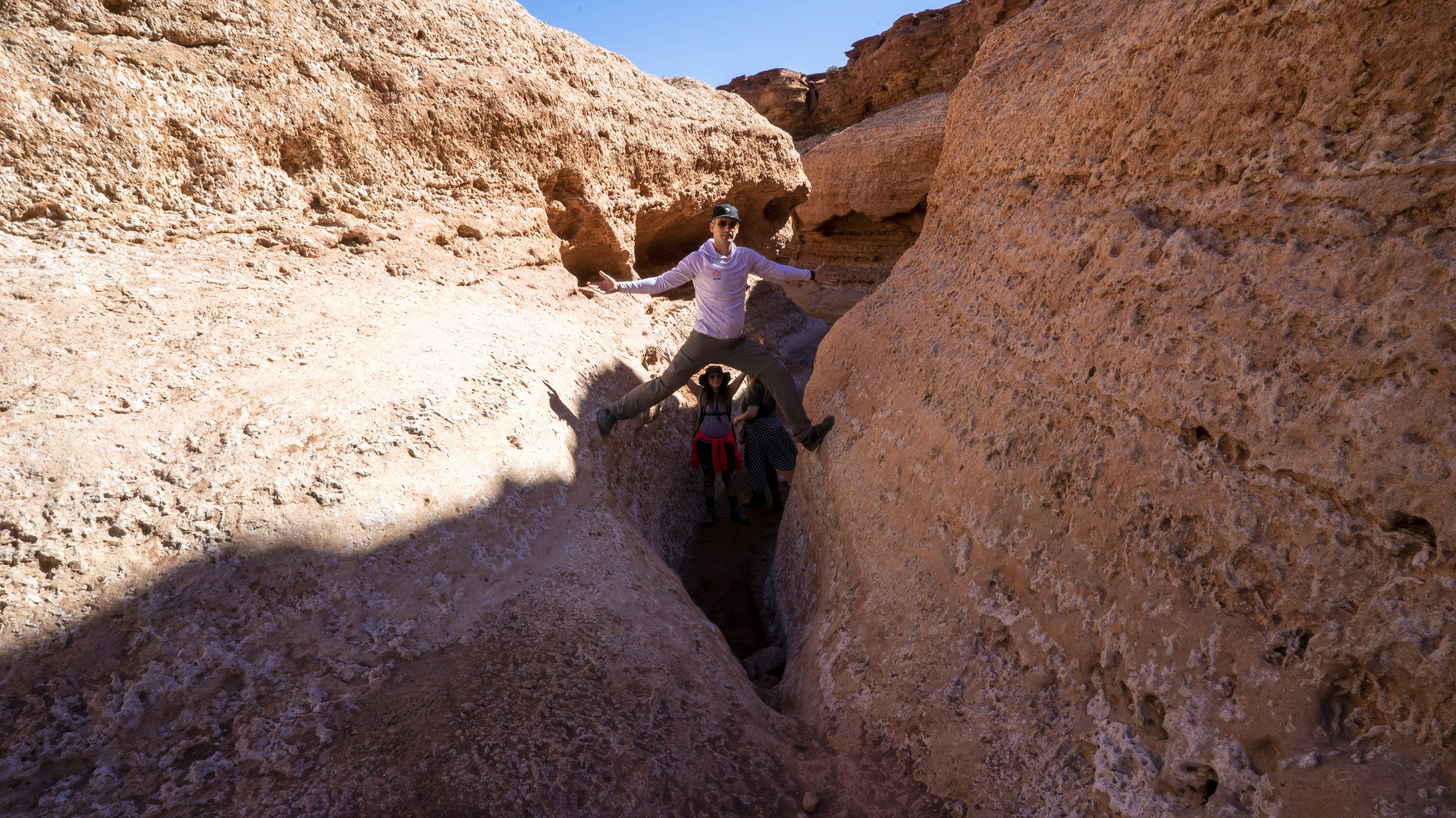a man standing in a narrow canyon between two large rocks