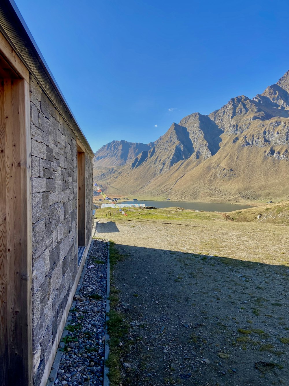 a wooden building sitting in the middle of a field