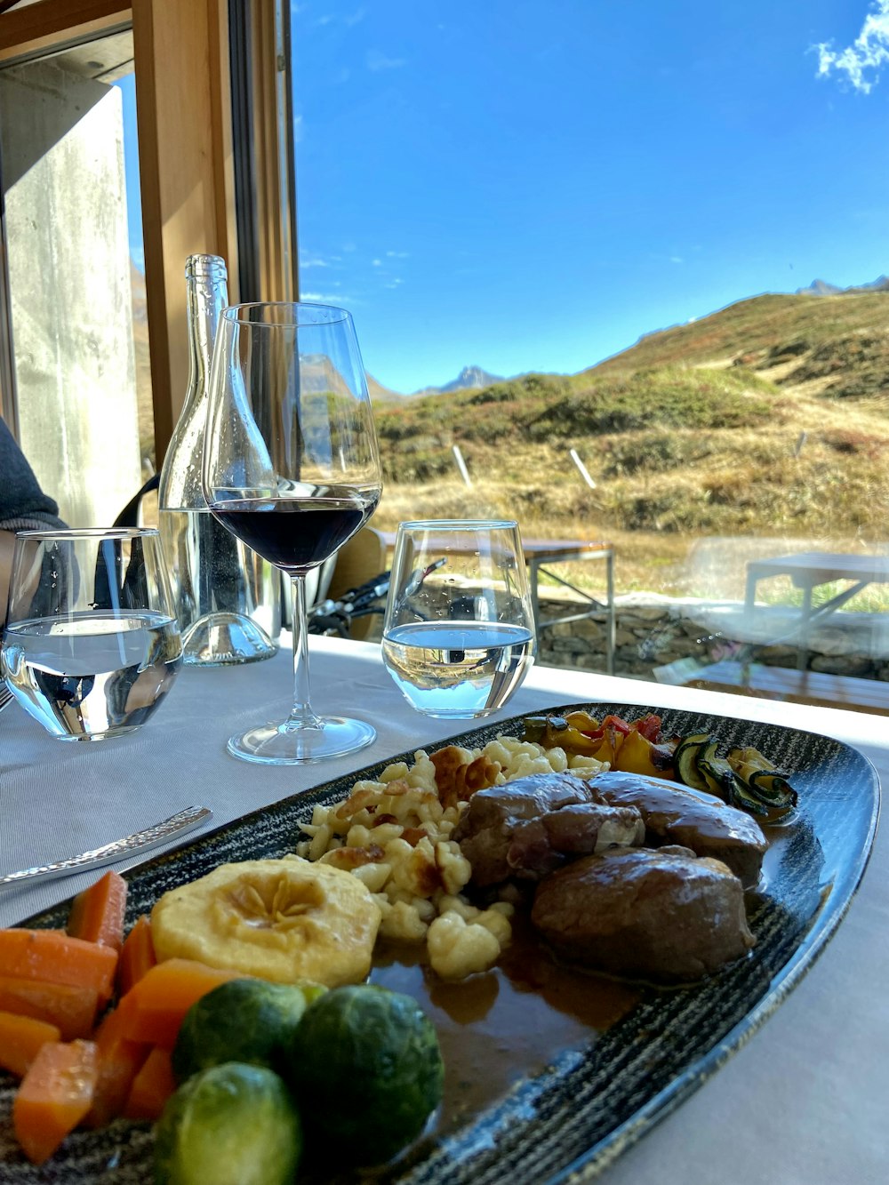 a plate of food on a table with wine glasses