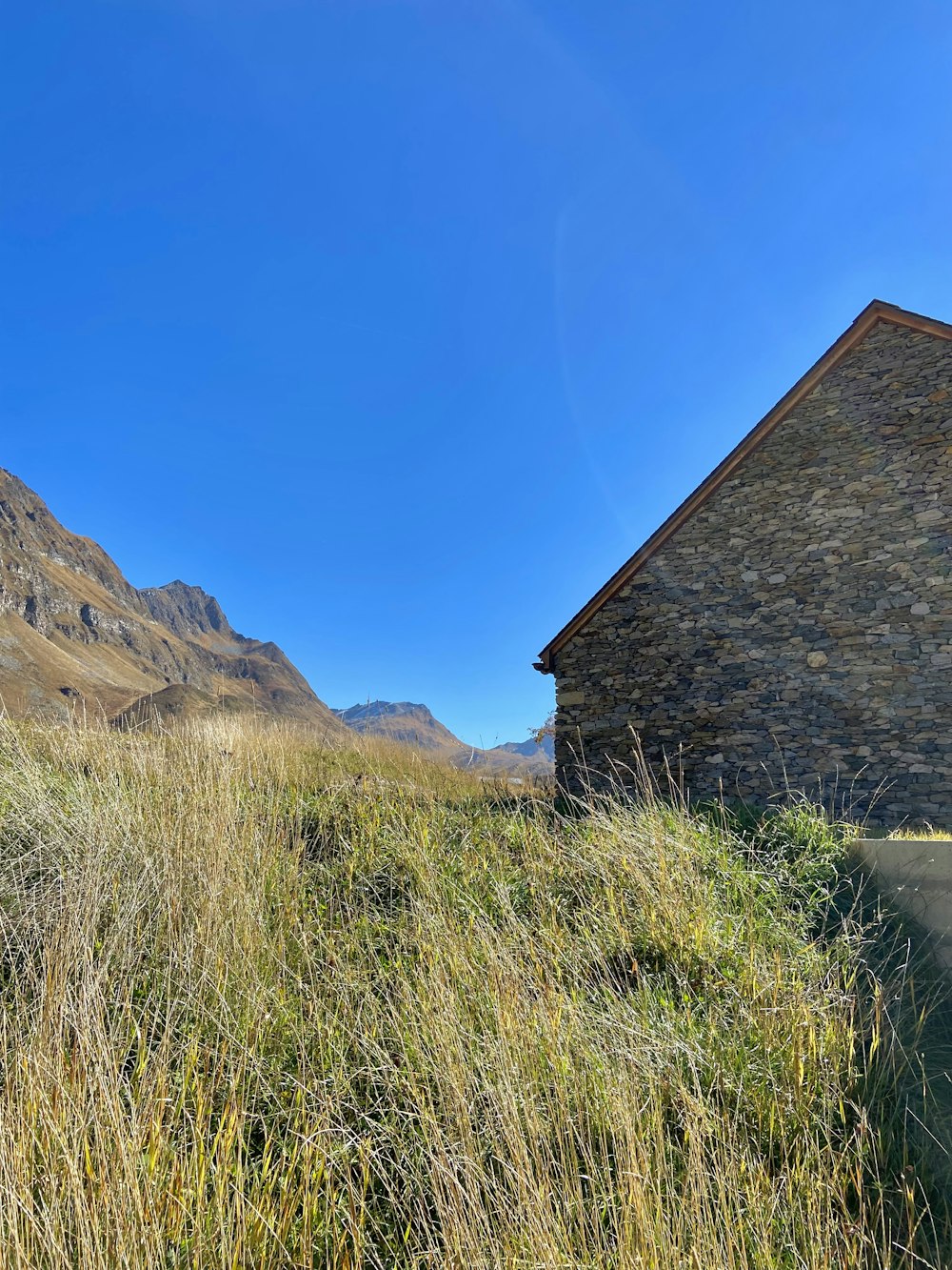 a stone building sitting on top of a lush green hillside