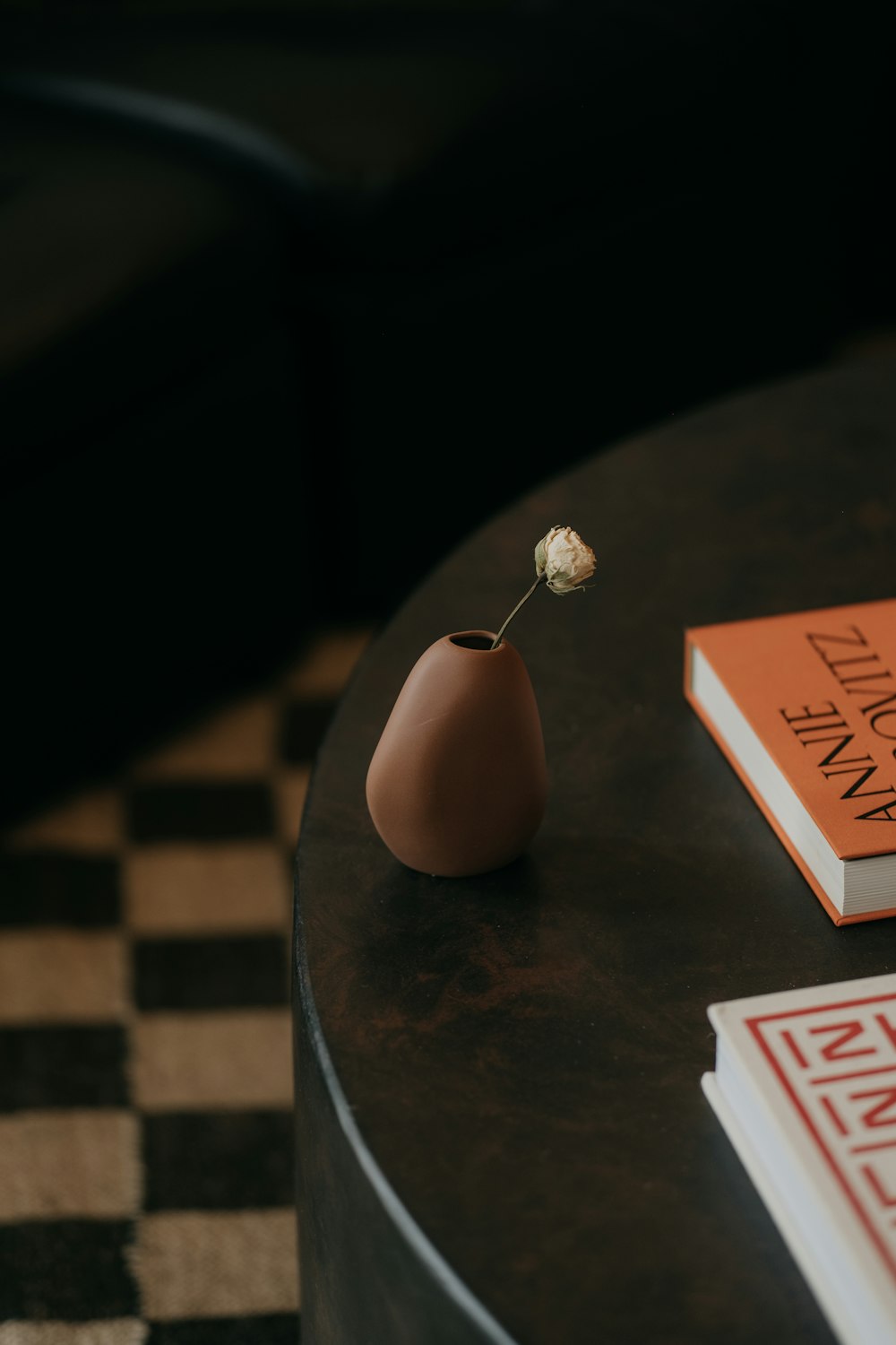 a small vase with a flower on top of a table