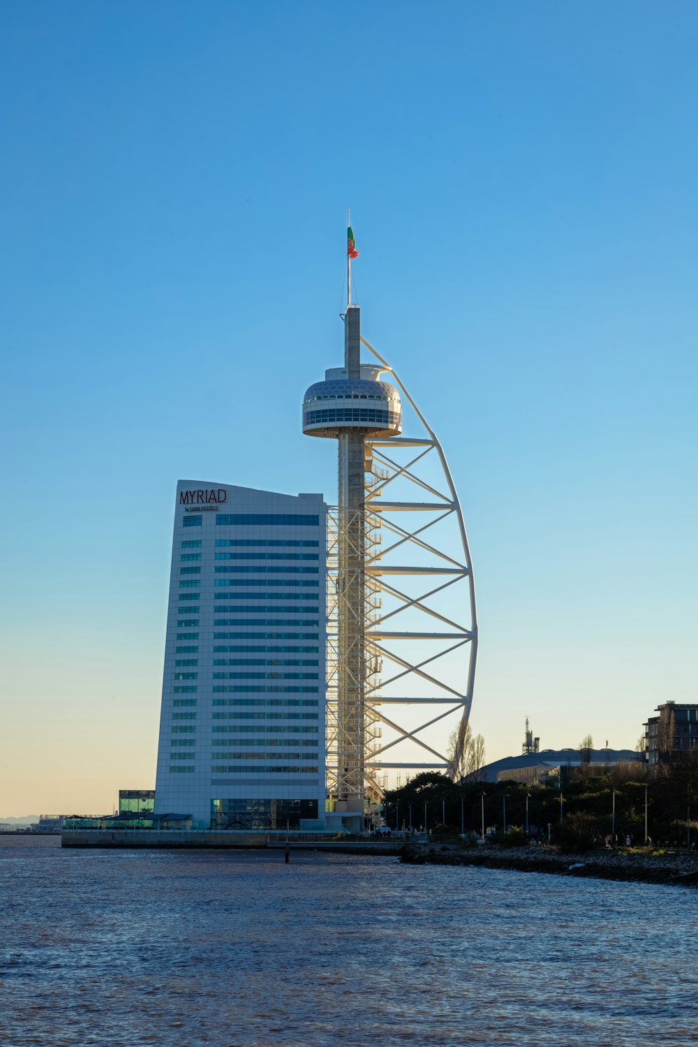 a tall white building sitting next to a body of water