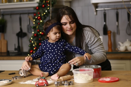 A cozy kitchen scene with a grandmother and child baking together, flour dusting the air.