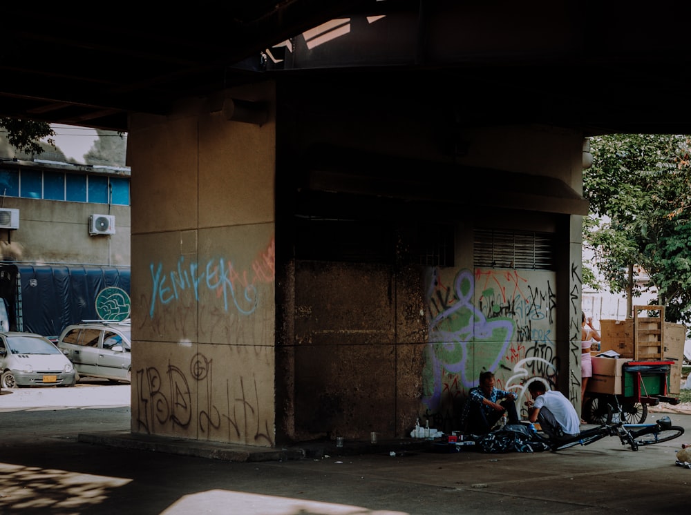 a group of people sitting on the side of a building