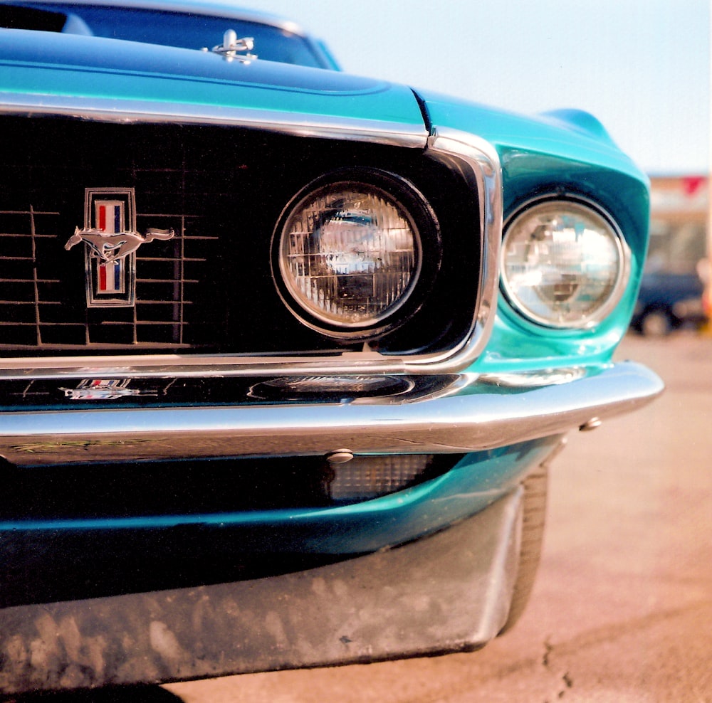 a close up of the front of a blue mustang