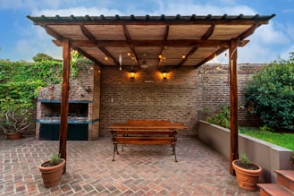 a wooden bench sitting under a wooden pergoline