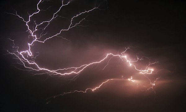 Lightning strikes in a dark night sky during a summer thunderstorm