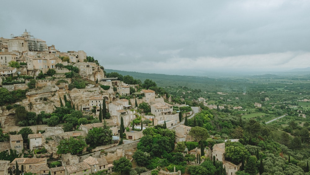 a village on top of a hill surrounded by trees