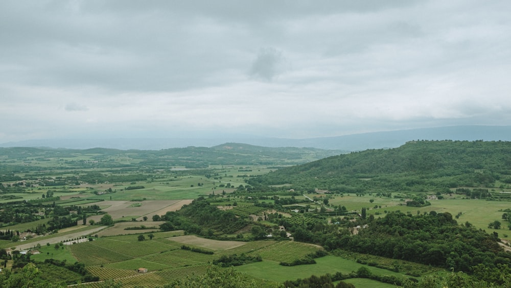 a scenic view of a valley with rolling hills in the distance