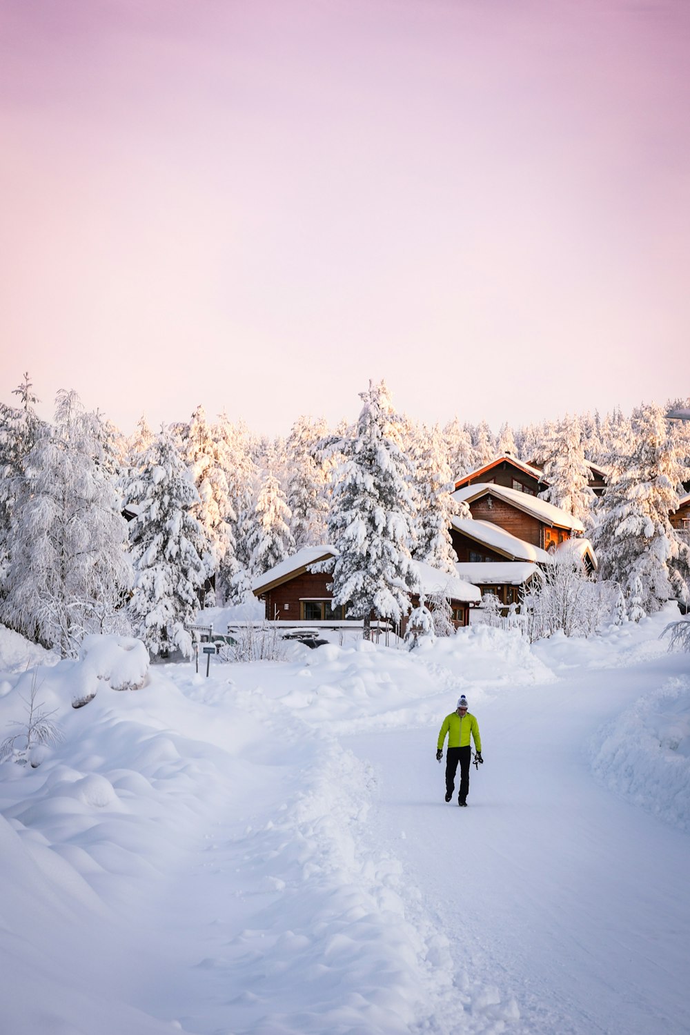 a person walking in the snow in front of a house