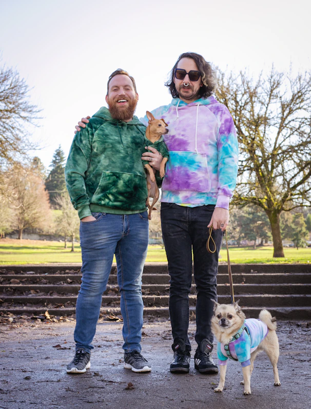 a couple of men standing next to a dog on a leash