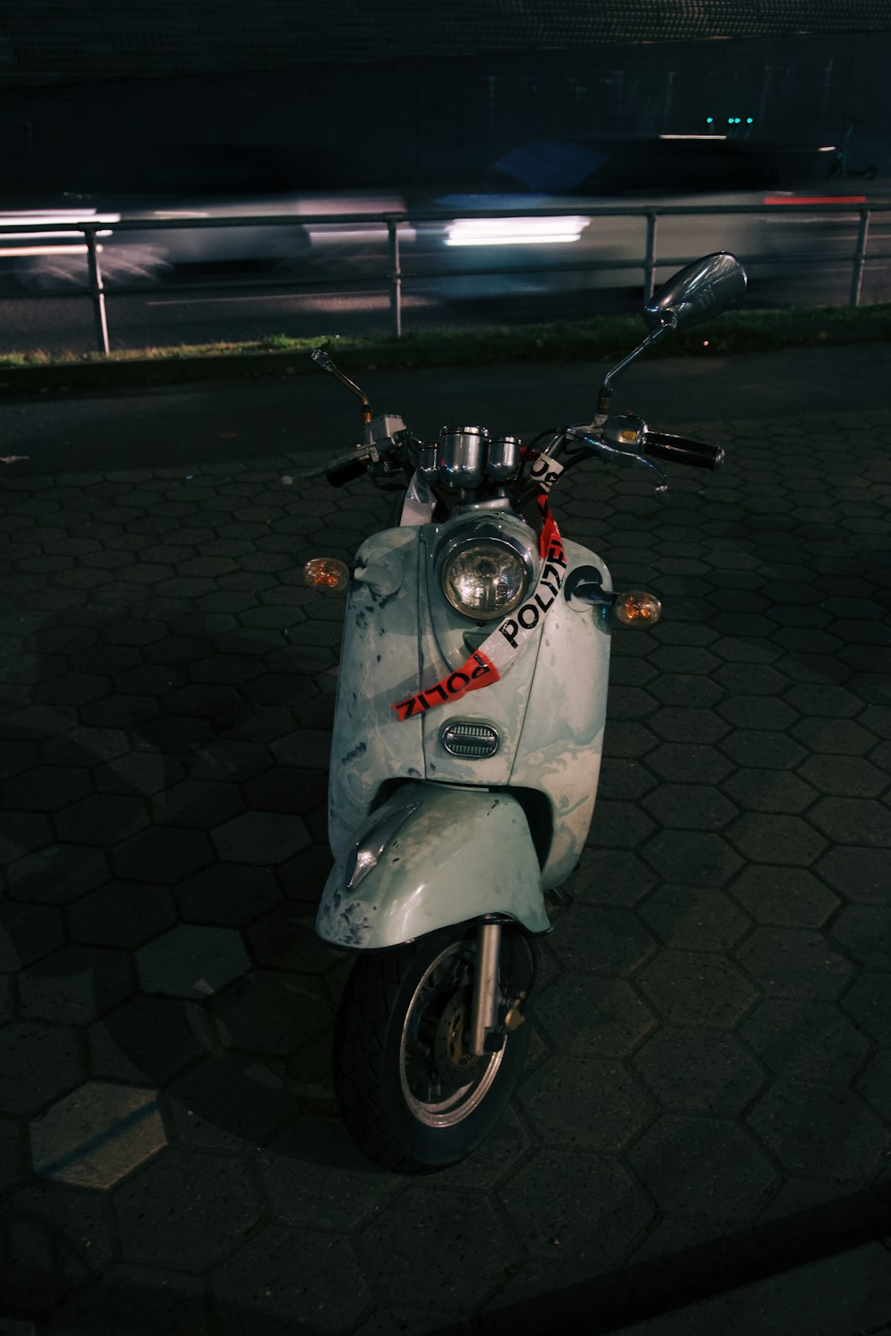 a motor scooter parked on a street at night