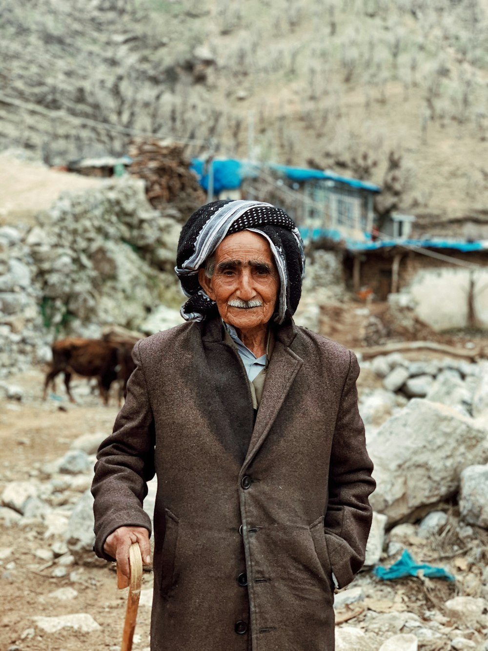 a man with a cane standing in a rocky area