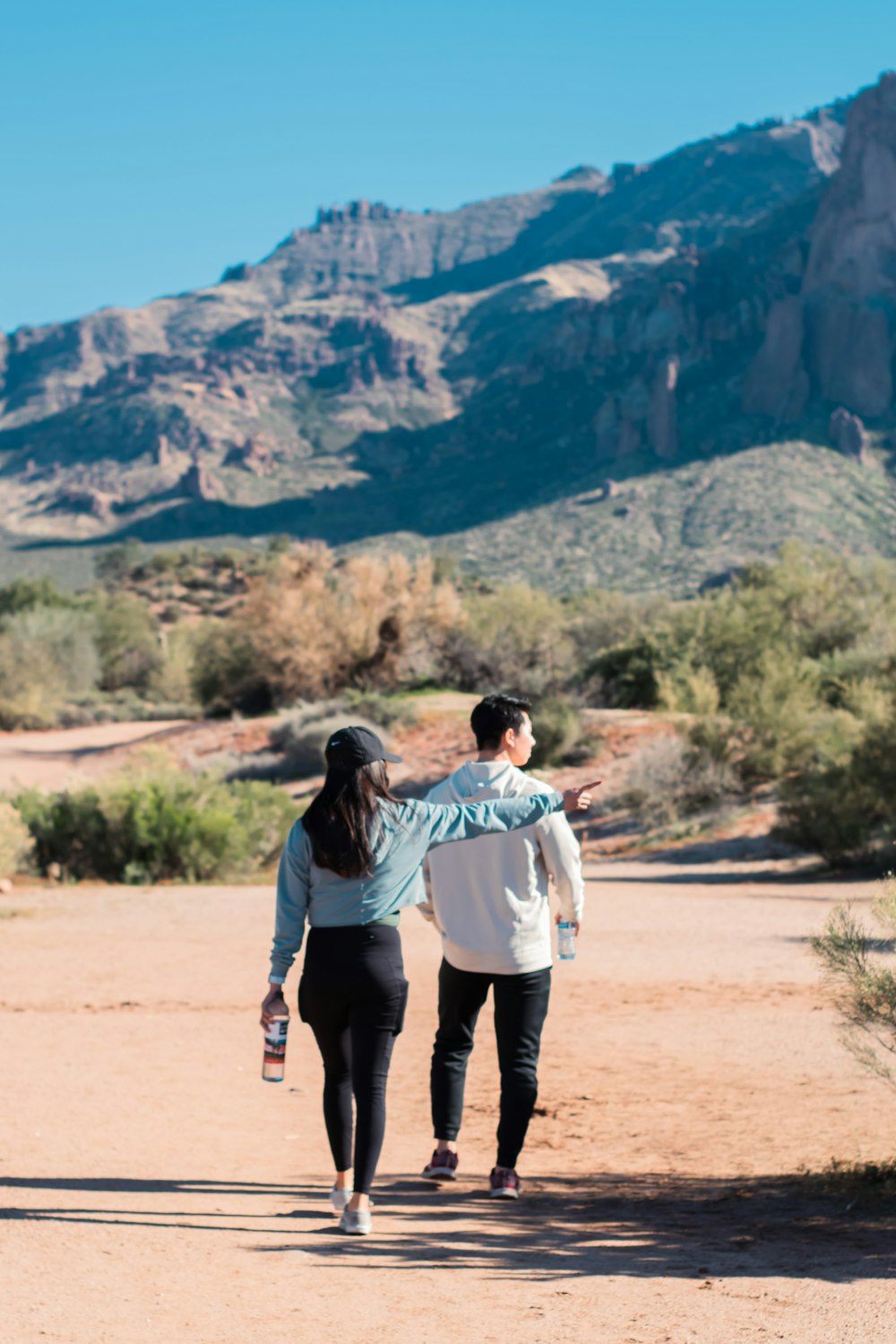 a man and a woman walking down a dirt road