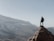 Hiker reaching the summit of Mt. Kenya with panoramic mountain views.