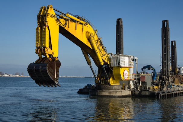 a large yellow excavator sitting on top of a body of water