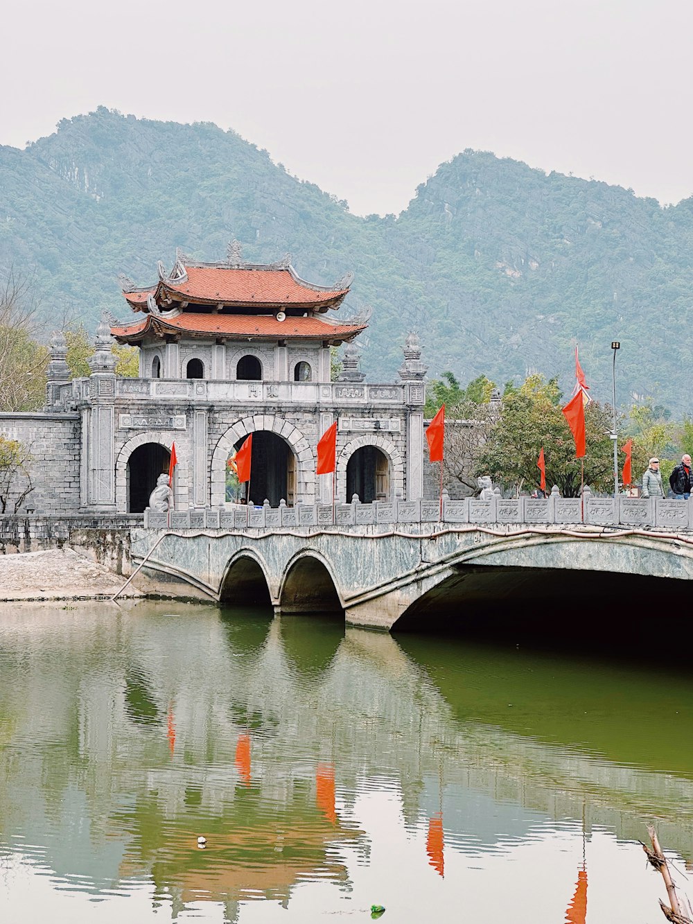 un puente sobre un cuerpo de agua con un edificio al fondo