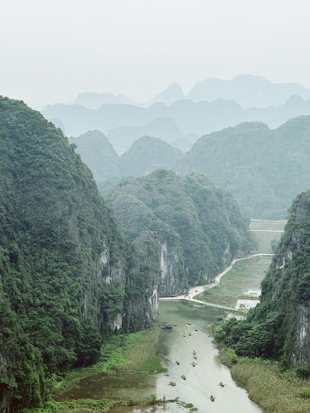 a river surrounded by mountains in the middle of a forest