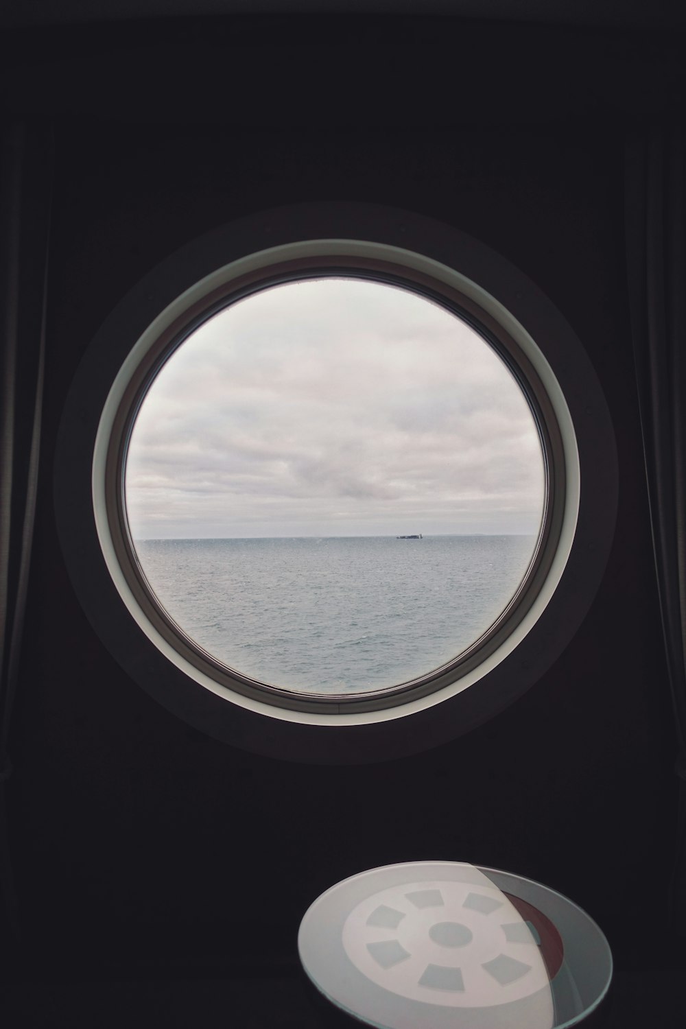 uma janela redonda com vista para o oceano
