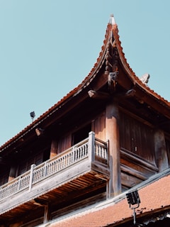 Traditional Himachali house with wooden balconies and sloped roof.