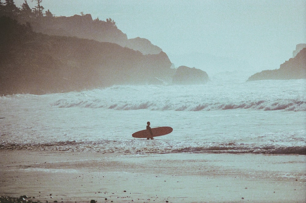 Una persona con una tabla de surf en el agua