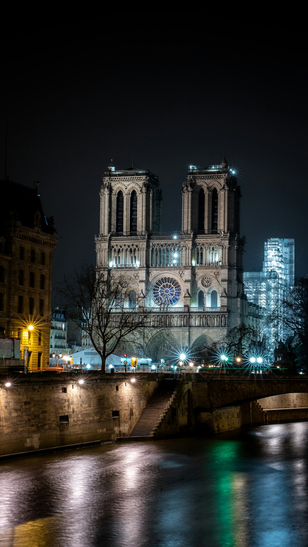 a large cathedral lit up at night over a river