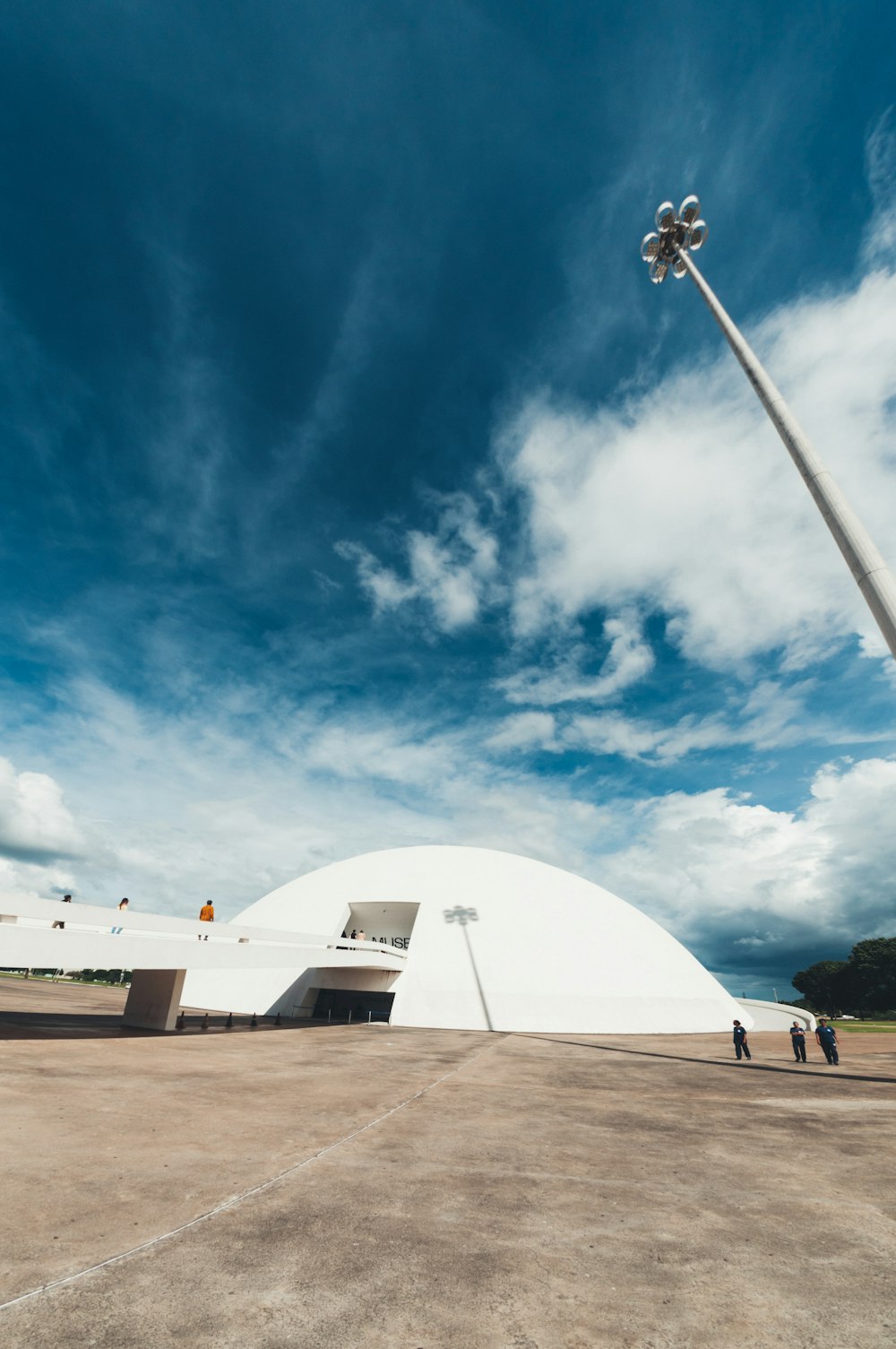 a large white building with a tall pole in front of it