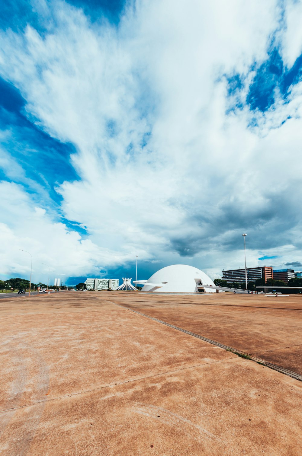 an empty parking lot under a cloudy blue sky