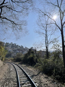 Scenic countryside railway track with charming countryside inns in the background under a blue sky.