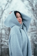 a woman in a blue hoodie standing in the snow