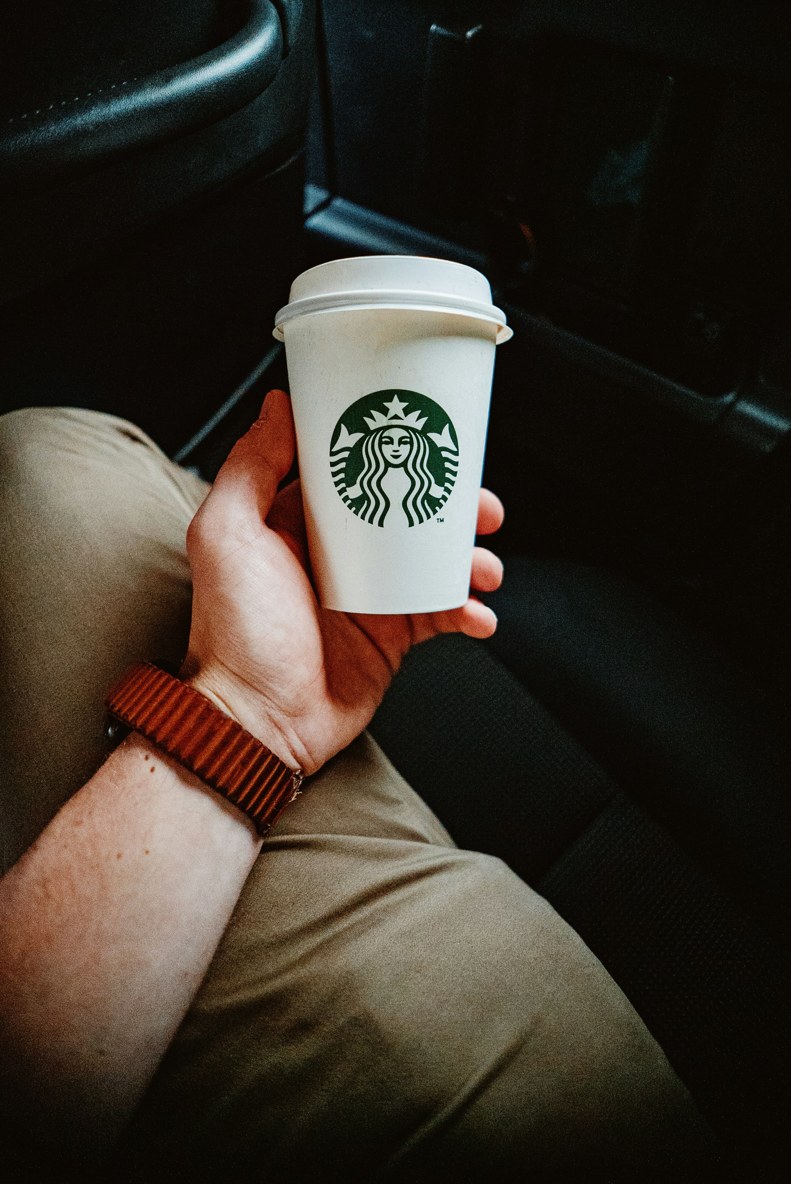 a person holding a starbucks cup in their hand