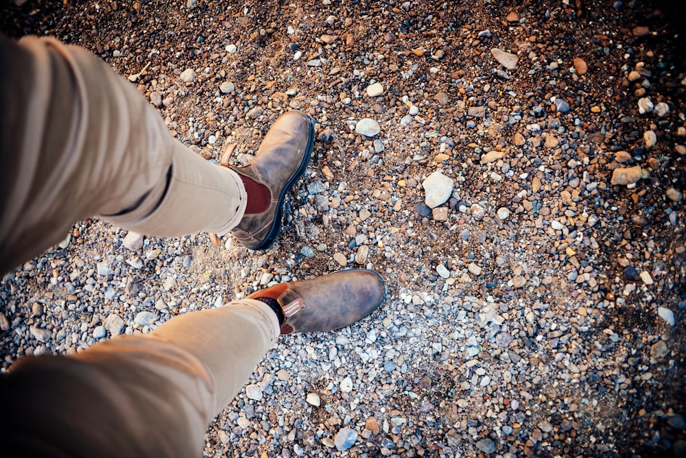 um homem de pé em cima de um chão coberto de cascalho