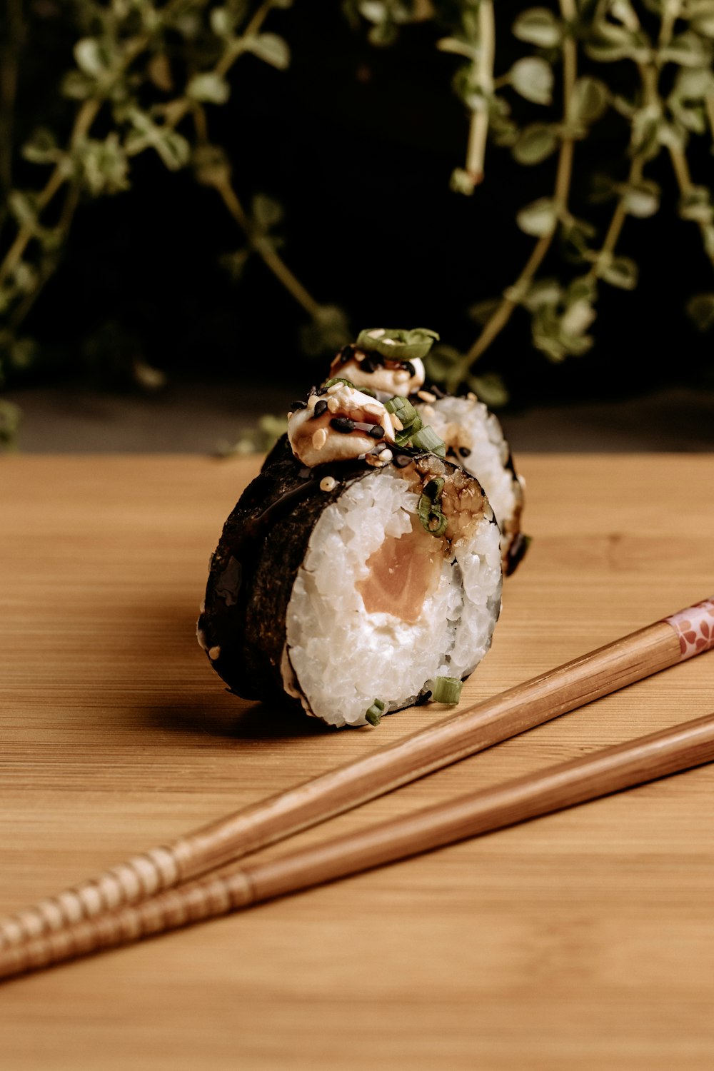 a close up of a sushi on a table with chopsticks