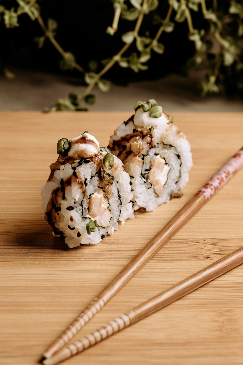 a close up of sushi on a table with chopsticks