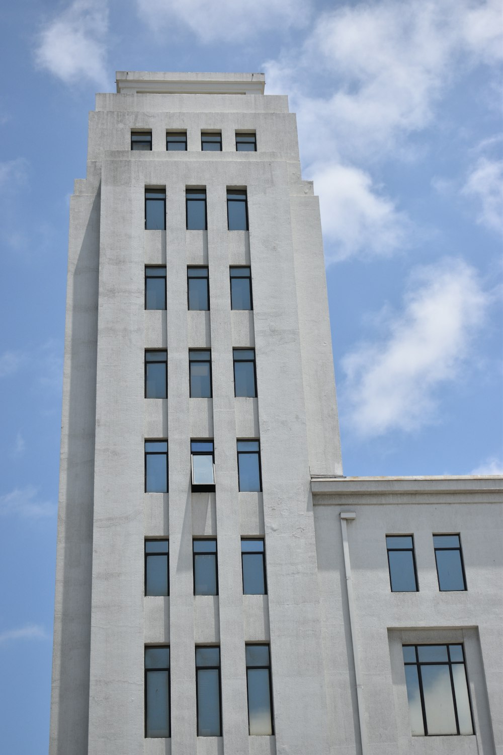 a tall white building with many windows and a clock