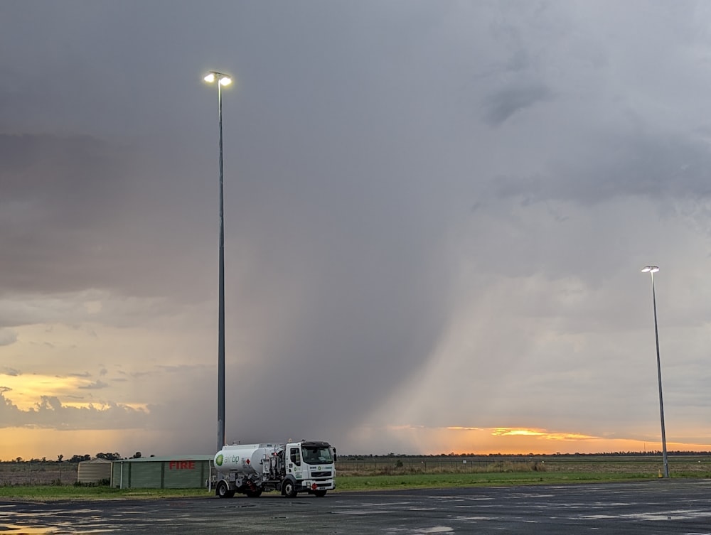 a large truck driving down a road under a cloudy sky