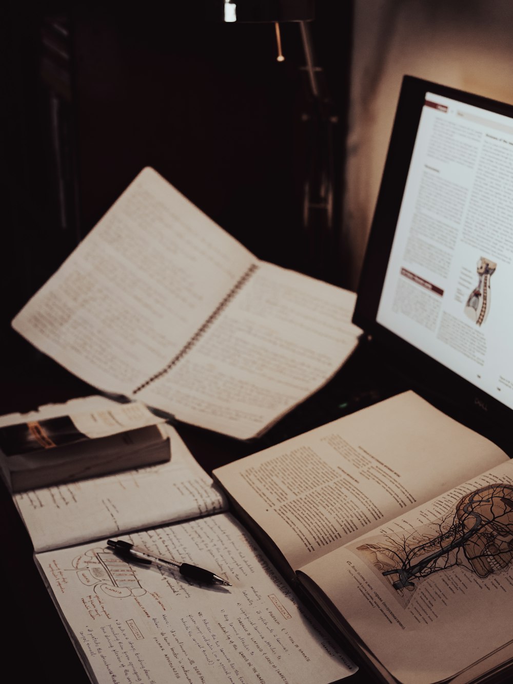 an open book sitting on top of a desk next to a computer