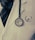 A close-up of a person wearing a white coat and a dark tie, with a stethoscope hanging from the neck. The stethoscope is positioned over the chest area, displaying the brand name 'Littmann' clearly. The coat has a logo on it.
