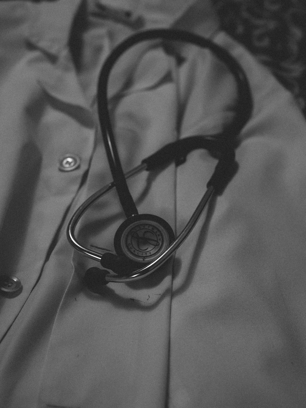 a black and white photo of a doctor's coat with a stethos