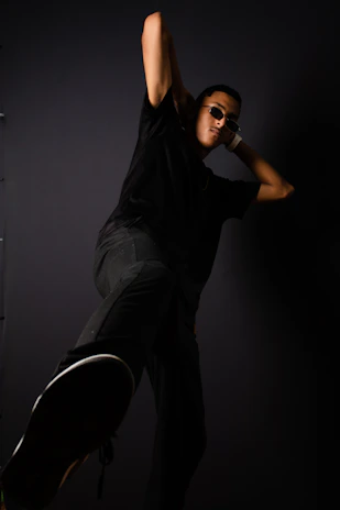 An editorial-style shot showcasing a model in dynamic movement with dramatic shadows.