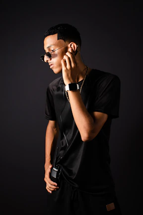 Close-up of a security officer’s hand adjusting a gold-accented earpiece, symbolizing discreet communication.